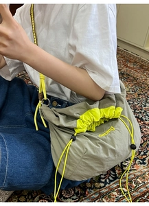 Détail du sac bandoulière en nylon avec cordon néon et broderie dabing de mode