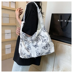 Detail view of white plush tote bag featuring black butterfly patterns and frayed edge design