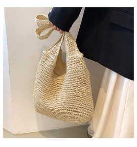 Dettaglio della trama intrecciata e del manico di questa borsa a spalla in paglia beige