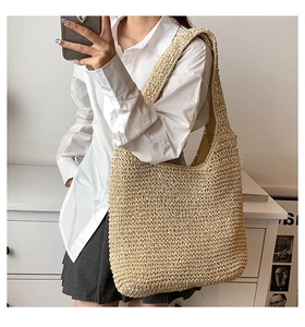 Dettaglio della grande borsa a tracolla in paglia intrecciata a mano con trama crochet