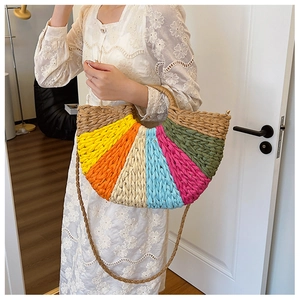 Detail of bohemian rainbow straw handbag with colorful woven patterns and shoulder strap