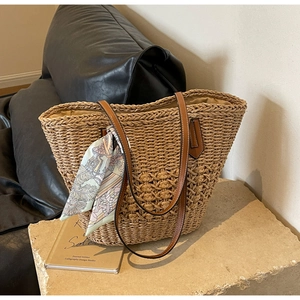 Minimalist straw woven tote bag with brown leather straps and elegant floral silk scarf