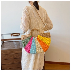 Handcrafted rainbow straw handbag featuring colorful woven patterns and round handle