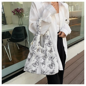 Detail of white lace tote bag with black butterfly patterns and textured fleece finish