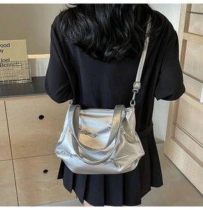Close-up of metallic silver PU leather shoulder bag featuring decorative bow accents