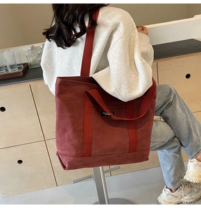 Detail shot of a brick red thick canvas tote bag showing its large capacity and strap
