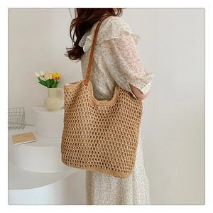 Detail of hand-woven hollow mesh knit tote bag with premium brown faux leather strap