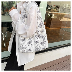 Detail of a large white canvas tote bag with black butterfly sketch print and fringed edges