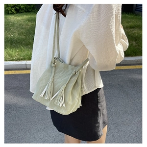 Détail du sac seau vert pois avec texture plissée et élégantes franges décoratives