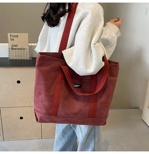 Deep red canvas tote bag shown worn over the shoulder for a daily casual look