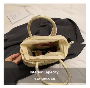 Capacité interne du sac en paille tressée avec des articles comme portefeuille et cosmétiques