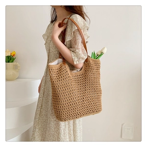 Close-up of hand-woven knit fabric texture and premium brown leather straps on the tote bag