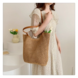 Detail showing the woven texture and brown leather strap of a khaki knit shoulder bag
