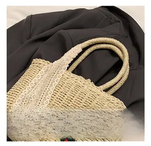 Détail du sac cabas en paille avec bordure en dentelle florale et fleurs au crochet