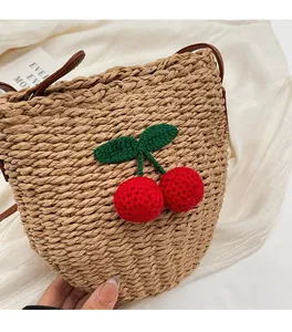 Detailed macro view of woven bucket bag featuring handcrafted red crochet cherry accents