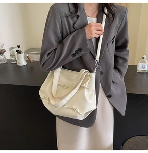 Detail of cream PU leather tote bag featuring stylish drawstring bow and dual shoulder straps