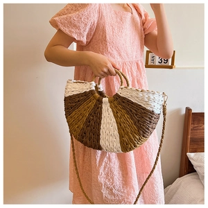 Detailed view of women's half-moon straw handbag with multicolor striped weave patterns