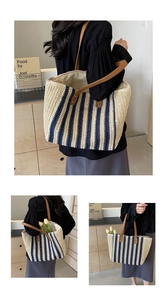 Close-up of navy striped straw tote bag showing brown leather handles and rivets