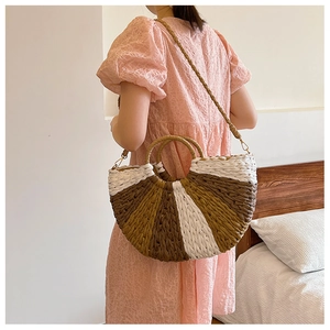Detail of a half-moon straw handbag with three-color woven stripes and round handles