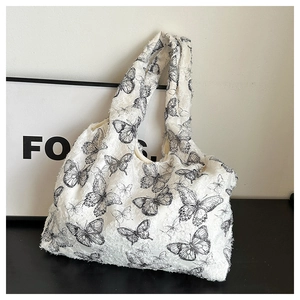 White tote bag with black butterfly floral patterns and textured embossed fabric