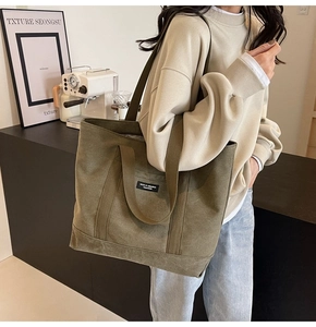 Detail of army green canvas tote bag with thick washed fabric and brand logo label