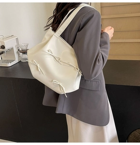 Close-up of white PU leather crossbody bag featuring three elegant bow knots