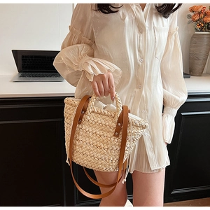 Detail of straw woven handbag with leather handles and drawstring lining for spring style
