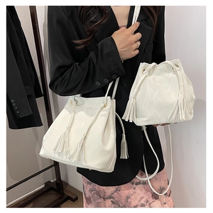 Détail de l'ensemble de sacs seaux blancs avec pompons à franges et cuir plissé