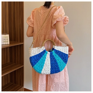 Detail of hand-woven striped straw handbag with round wooden handle and braided strap