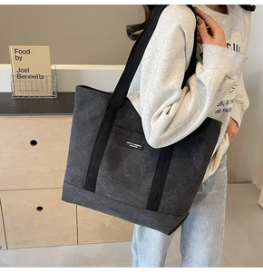 Close-up of charcoal canvas tote bag showing the textured fabric and black nylon strap