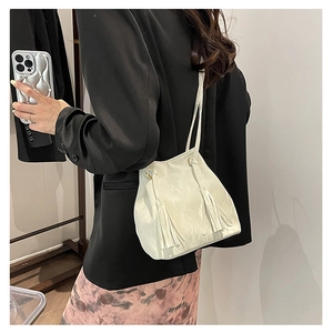 Sac seau chic blanc crème avec de longues franges tendance et une fine bandoulière en cuir