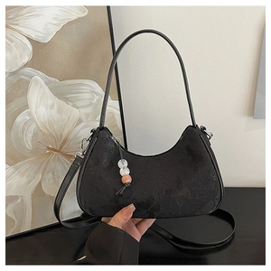 Minimalist black half-moon crossbody bag with subtle butterfly pattern and bead charm