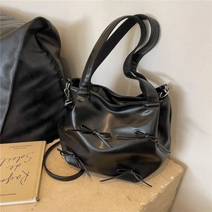 Minimalist black PU leather handbag with decorative bows and adjustable shoulder strap