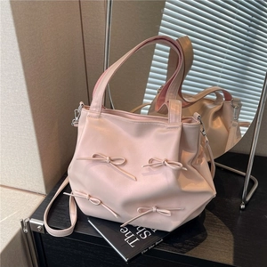 Pink PU leather crossbody bag with decorative bows and adjustable shoulder strap