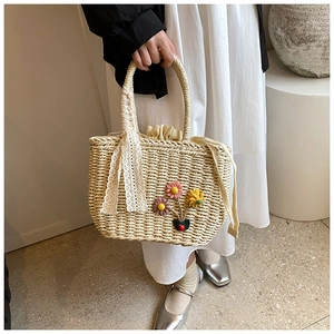 Détail du sac cabas en paille tissé main avec fleurs 3D et ruban en dentelle élégant