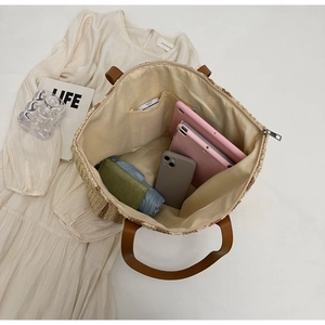 Internal view of a woven straw tote bag showing large capacity and smooth zipper closure
