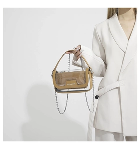 Détail du sac cabas en PVC transparent avec pochette en cuir camel et bandoulière chaîne
