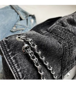 Close-up of vintage denim tote bag showing leather-woven chain and stitching detail