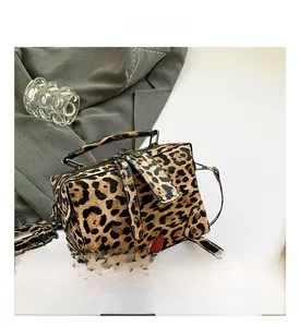 Close-up of leopard print PU leather bag with metallic studs and vintage lock