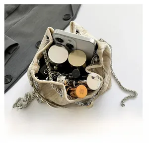 Interior view showing capacity of champagne crossbody bag with smartphone and cosmetics
