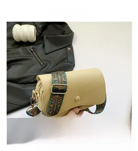 Detail der cremefarbenen PU-Leder Umhängetasche mit Narbenstruktur und gewebtem Gurt