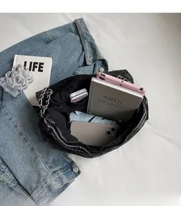 Macro view of the spacious inner compartment and pockets of this black denim tote bag