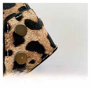 Macro shot of leopard print PU leather bag with white stitching and silver rivets details
