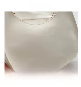 Close-up of cream white PU leather saddle bag showing fine texture and sewing details