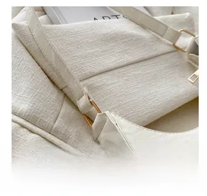 Detailed close-up of glossy white PU leather handbag with golden metal hardware ring