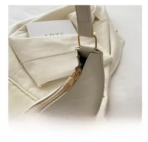 Detail view of glossy cream PU leather texture with high-quality gold metal zipper