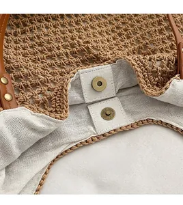 Detail of premium straw woven bag featuring a bronze magnetic snap and cotton lining