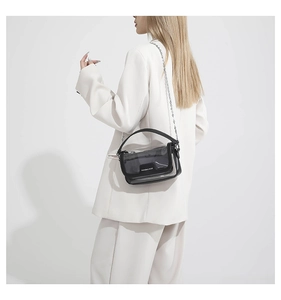 Détail du sac bandoulière en PVC transparent avec bordure noire et chaîne argentée chic