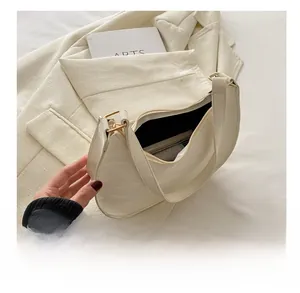 Detail view of the cream white PU leather half-moon bag interior showing its large capacity