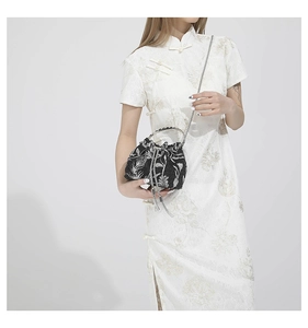 Detail of black and white jacquard floral bucket bag with silver metal handle and chain